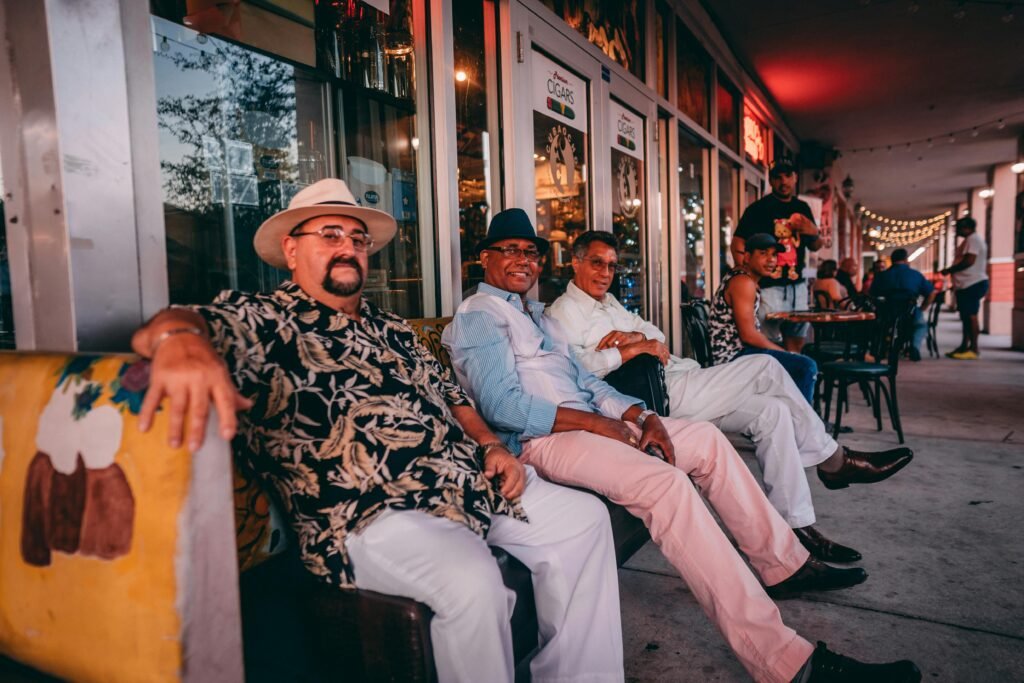 A group of men sit together enjoying a relaxing evening outside a Miami cafe.